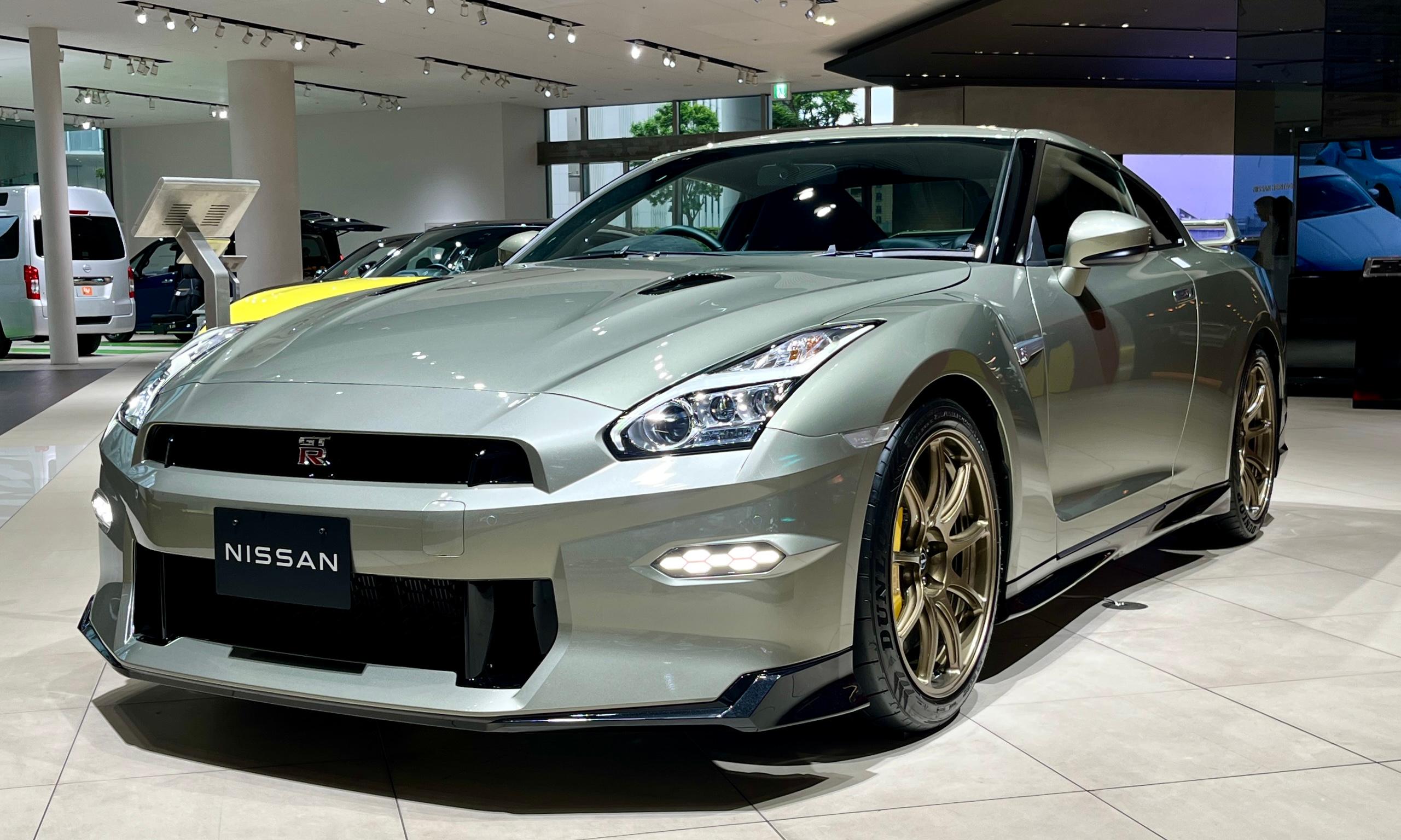 Silver 2024 Nissan GT-R T-spec displayed indoors, viewed from the front left.