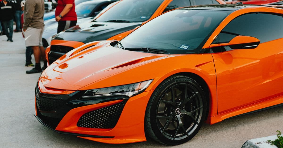 Orange second-generation Acura NSX at an outdoor car show.