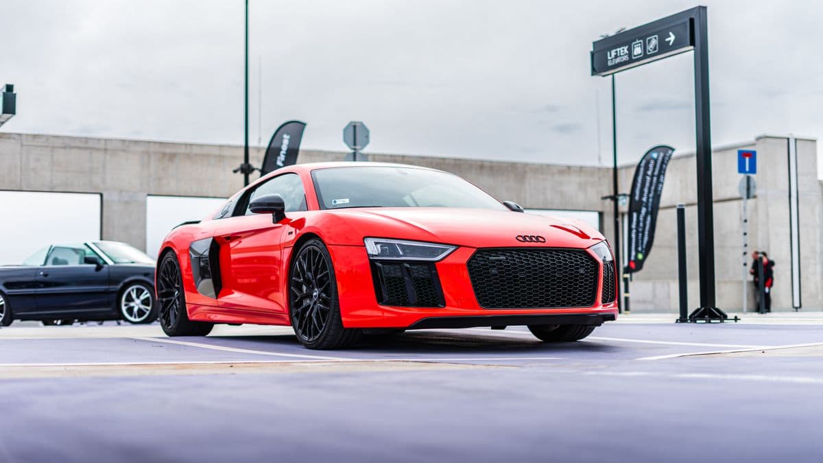 Photo: Bálint Varga / Pexels Red Audi R8 parked outdoors, viewed from the front and side.