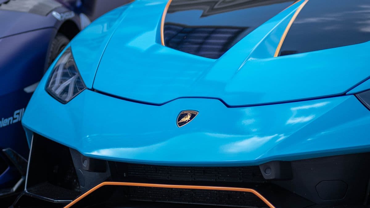 Front bodywork and badge of a blue Lamborghini Huracán.