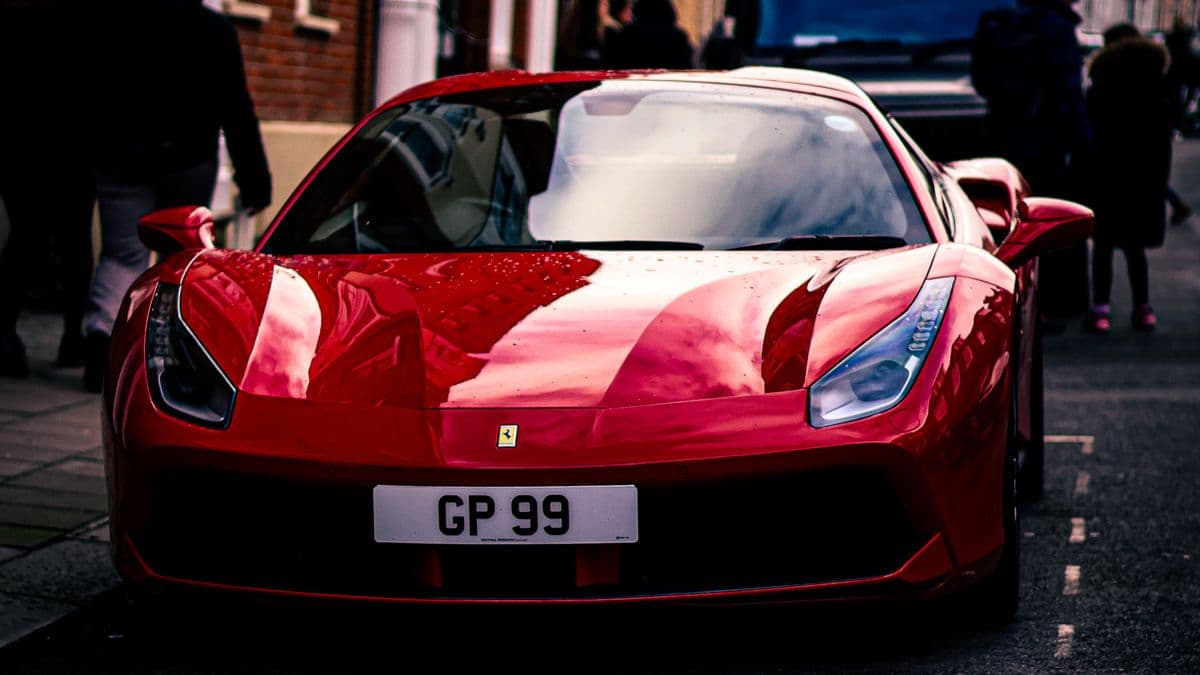 Red Ferrari 488 parked on a city street, viewed from the front.